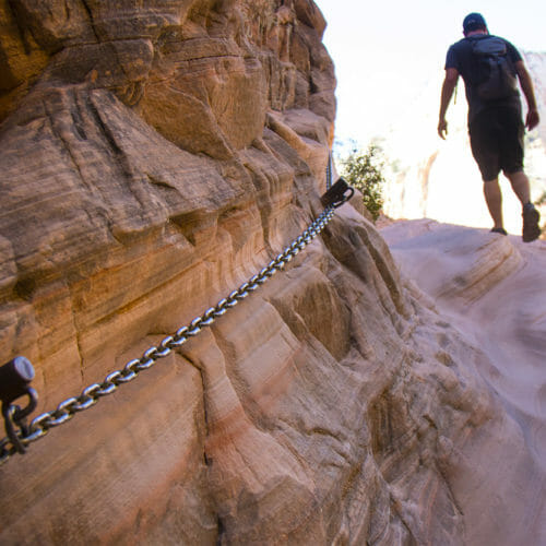 Man hiking up Hidden Canyon with chain
