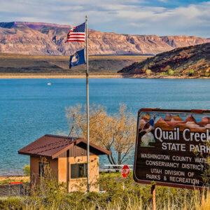 Entrance sign in front of lake reading Quail Creek State Park
